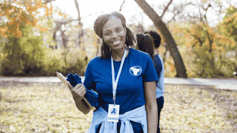 charity volunteer smiles and holds a clipboard