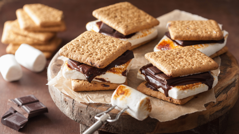 Four smores - roasted marshmallows and a slab of chocolate sandwiched between two biscuits