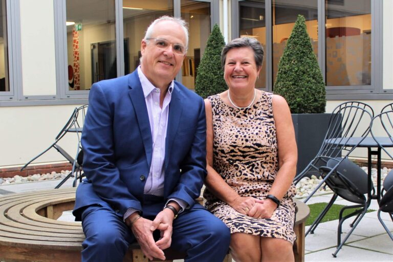 Andrew Richards and Mary Hooper sit together on a bench in the garden of the Exeter office