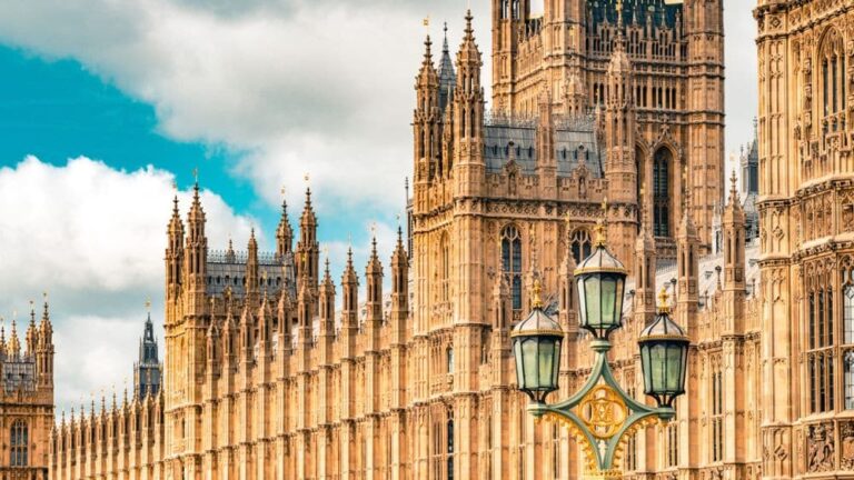 A street lamp stands in front of a section of the Houses of Parliament.