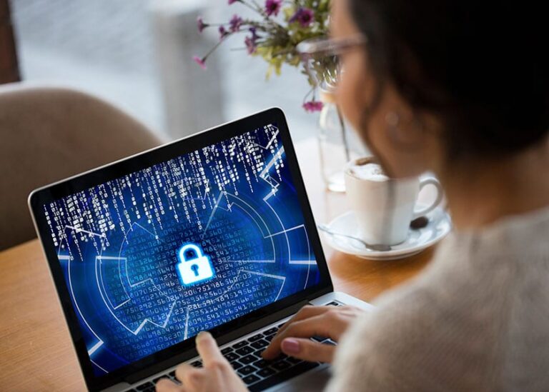 A lady is looking at a laptop with numbers and a padlock on the screen.