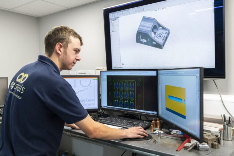 A man employed by DP Seals is observing a computer screen displaying the manufacturing process of rubber mouldings for certain equipment.