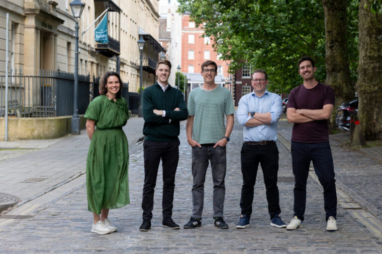 Five colleagues standing on a cobbled street in a South West city.