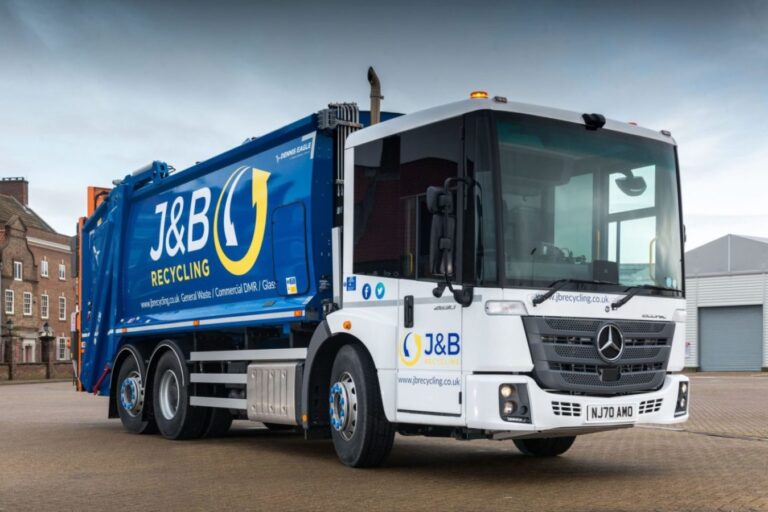 A J&B recycling lorry next to garage.