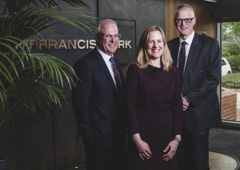 Andrew Richards ,Nicola Manclark and John Endacott strike a pose in front of the Francis Clark sign at the Bristol office.