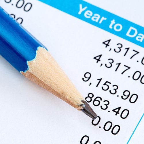 A close up image of a pencil resting on a payslip.