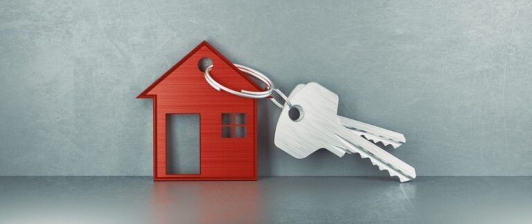 A set of keys attached to a keyring in the shape of a red house.