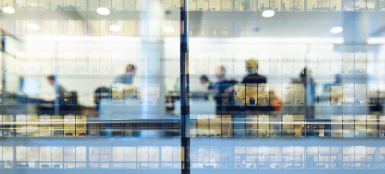 Offices teeming with workers are ensconced behind glass panes.