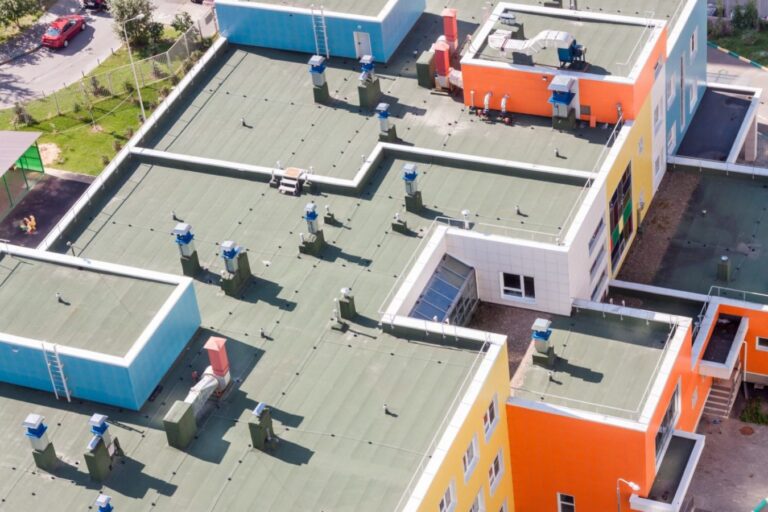 An aerial view of an air con system on top of an orange and yellow building.