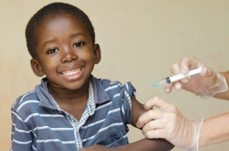 A young boy clenched his teeth as he waits for a vaccine to be administered.