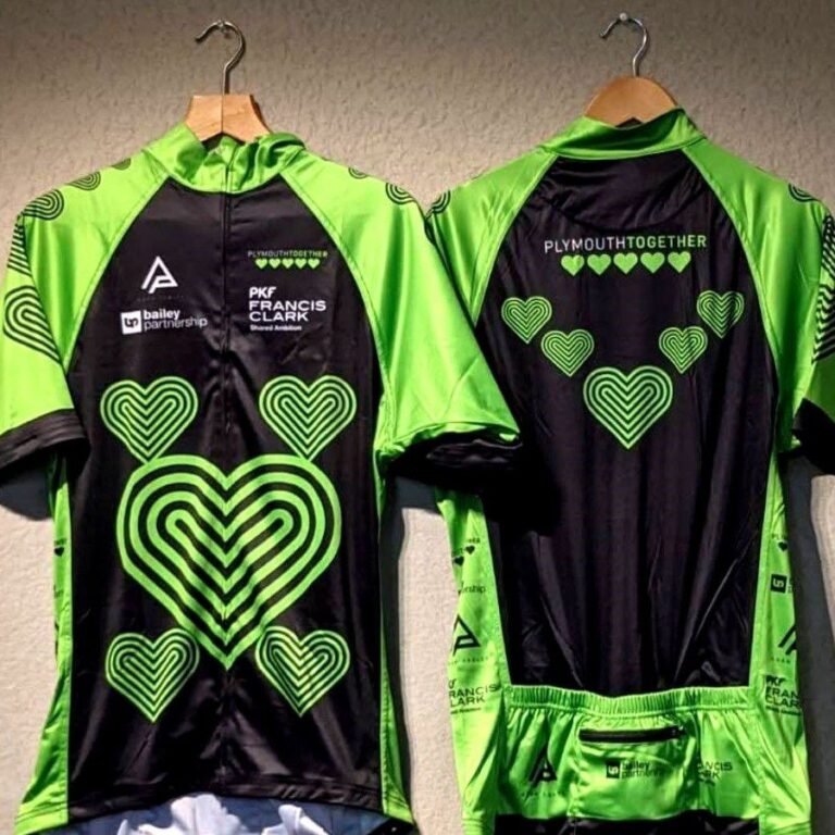 Displayed are two jerseys worn during a cycling challenge to support Plymouth Together, with one facing front and the other turned to the back.