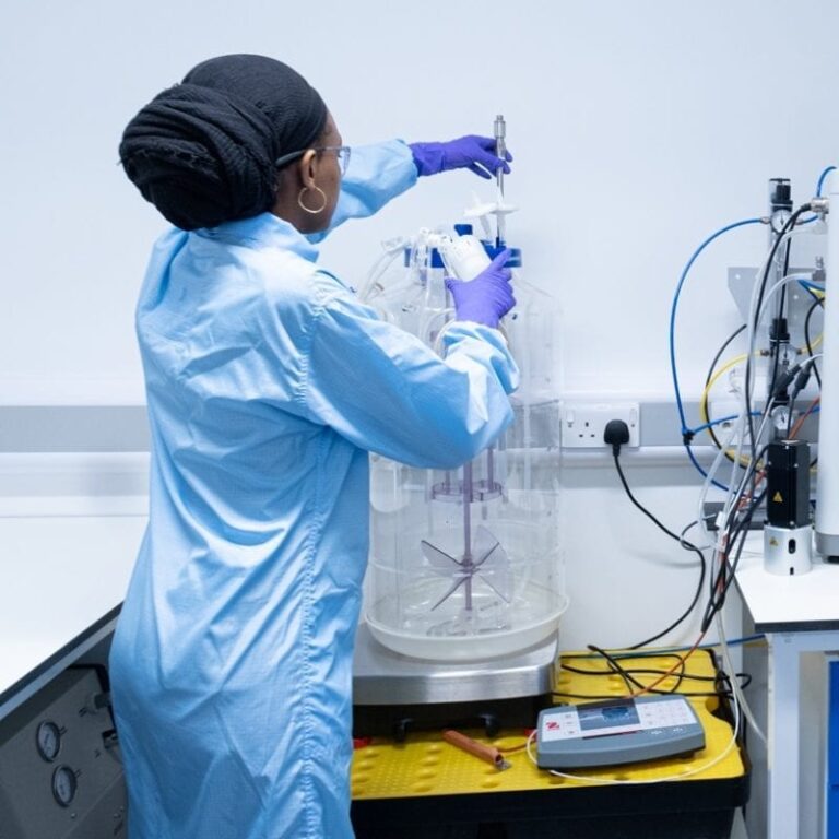 A scientist checks the gauge on a piece of equipment in a laboratory at eXmoor Pharma.