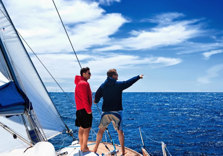 Two men on sailing yacht looking at horizon