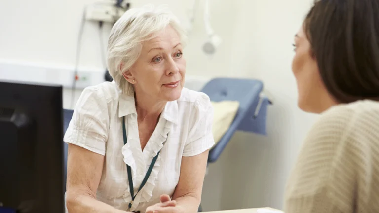 A lady doctor listening intently to a patient.