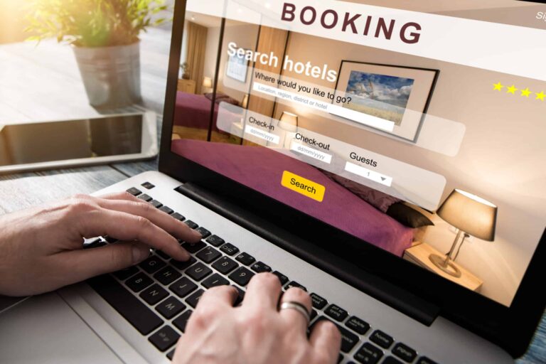 A close up view of a laptop screen and keyboard as someone conducts a hotel booking search.