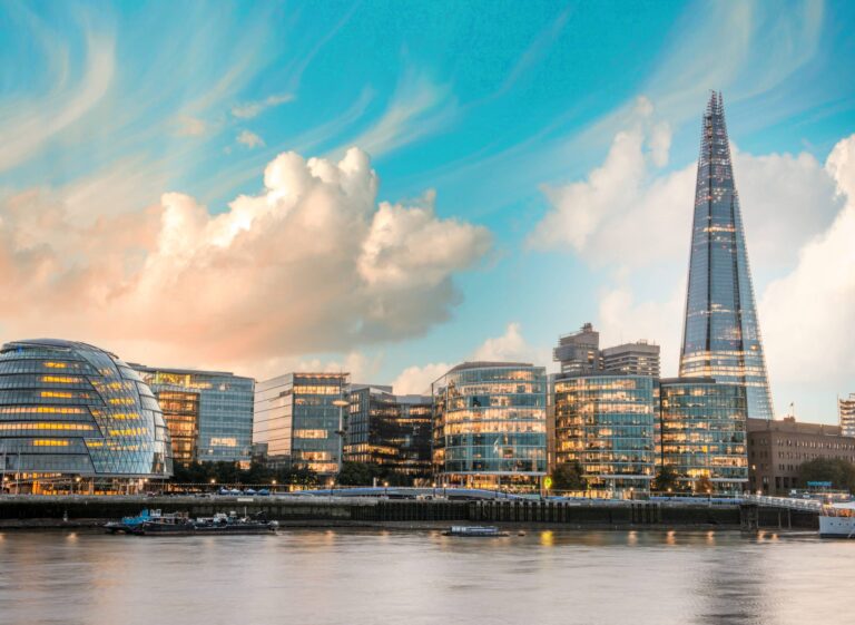 A view across the river Thames of an illuminated London sky line, with the Shard towering above the other buildings.