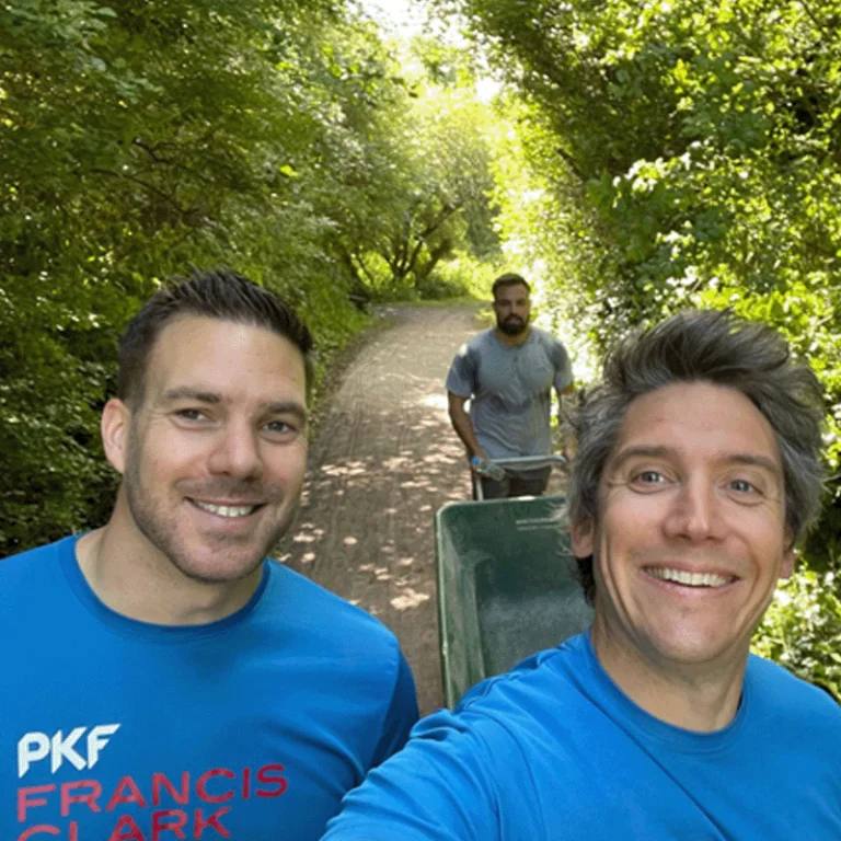 Torquay male colleagues on volunteering day with wheelbarrow on footpath