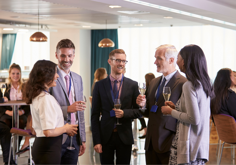 five business people chat at a drinks reception