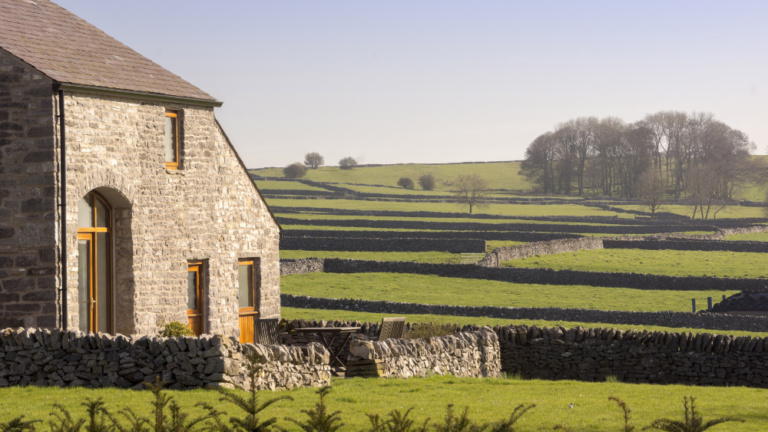 A converted barn looking out over farmland.