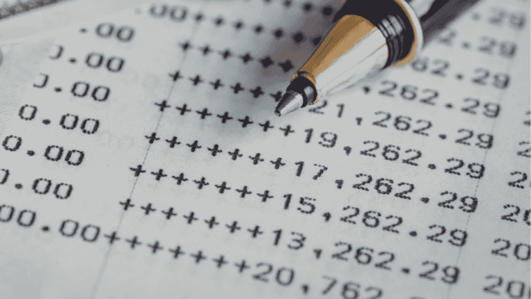 A pen rests on a printed balance sheet