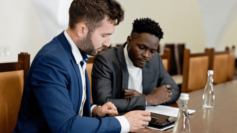 Two men in suits discussing a business transaction.