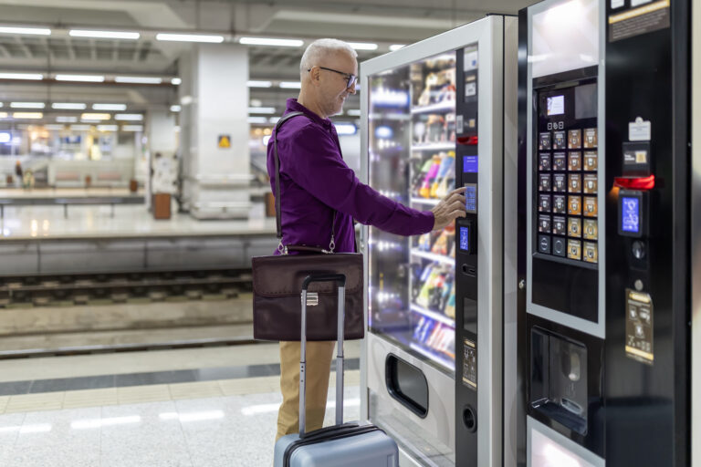 A man buying a snack from a vending machine at a railway station