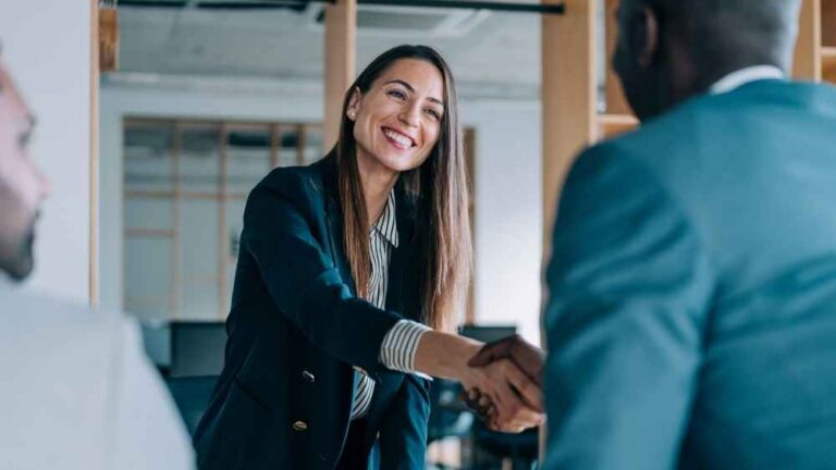 New finance director shakes a colleague's hand