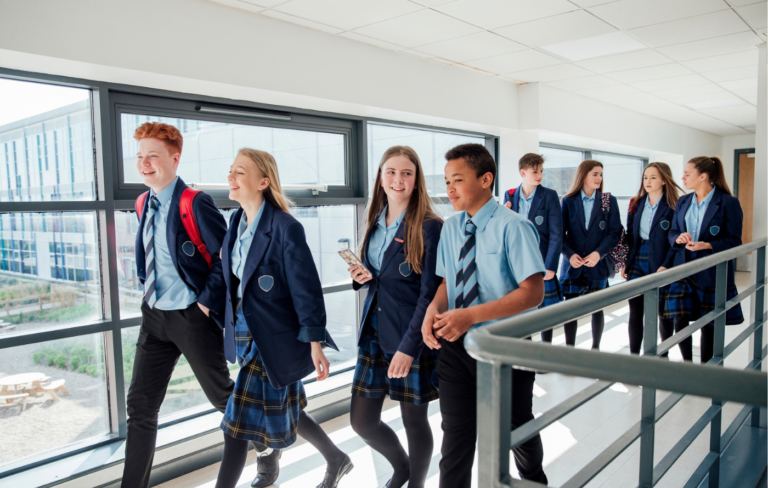 A group of secondary school children walking along a school corridor